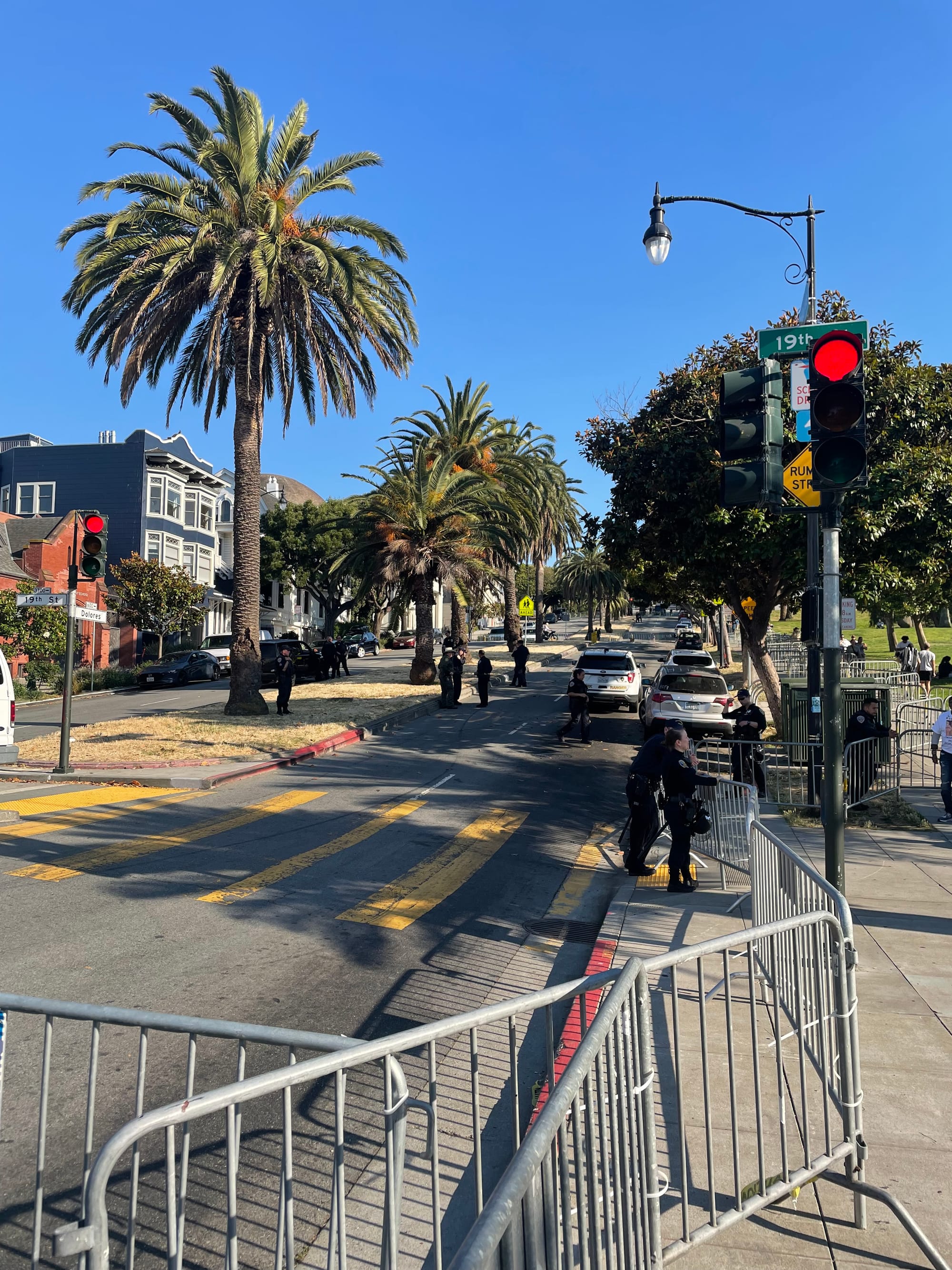 Dolores Street and the adjacent sidewalk, completely barricaded, with cops, sheriffs, and park rangers milling about (Photo credit: Safe Street Rebel)